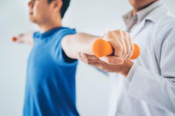 physiotherapist-man-giving-exercise-with-dumbbell-treatment-about-arm-shoulder_18497-1110